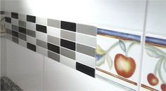 a tiled wall with black and white tiles on the bottom, and an apple painted on top