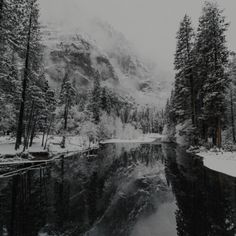 a river surrounded by snow covered mountains and trees