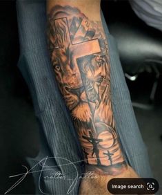 a man with a cross and lion tattoo on his arm