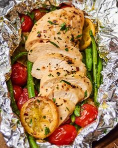 chicken and asparagus wrapped in tin foil with tomatoes, green beans and cherry tomatoes