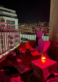 a person sitting at a table on top of a roof next to a laptop computer