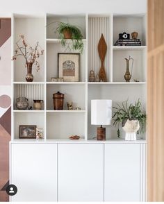 a living room filled with lots of white furniture and bookshelves on top of each other