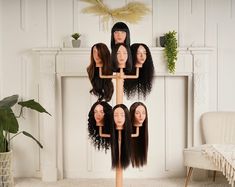 a group of mannequin heads with long hair in front of a fireplace