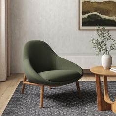 a chair and table in a room with a painting on the wall behind it,