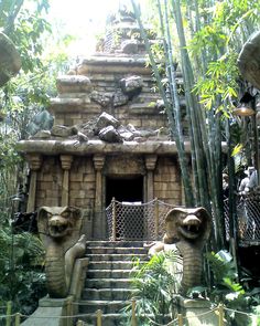 a stone building with statues on the steps and trees in the backgrouds