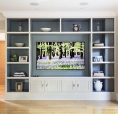 a living room filled with furniture and a flat screen tv on top of a wall