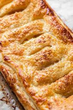 a close up of a pastry on a piece of parchment paper with other food items in the background