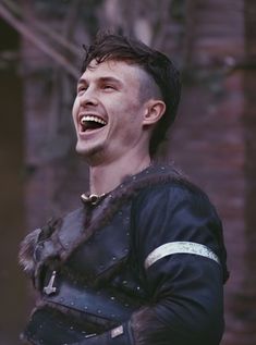 a man wearing a leather armor laughing