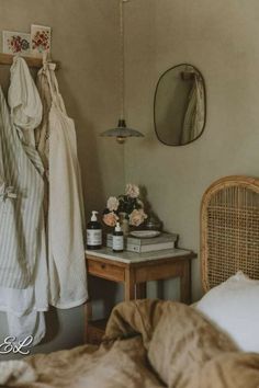 a bedroom with clothes hanging on the wall and a bed in front of a mirror