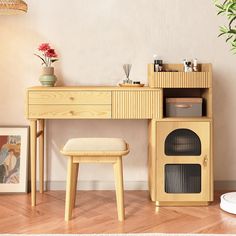 a wooden desk with a stool next to it and a potted plant in the corner