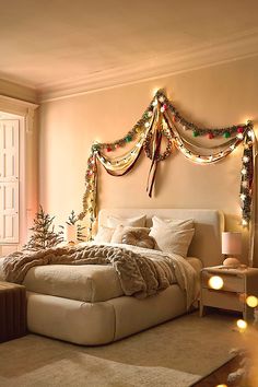 a bedroom decorated for christmas with lights on the headboard