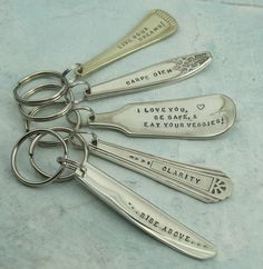 six personalized silverware keychains with engraved sayings on the handles and sides