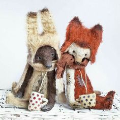 two stuffed animals sitting next to each other on top of a white surface with polka dots