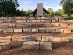 stone steps in front of a building with a fire place and picnic table on the other side