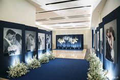 a room with blue carpet and pictures on the wall, flowers are in vases