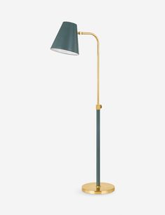 a gold and green floor lamp with a black shade on the top, in front of a white background