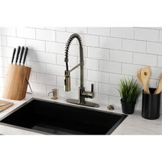 a kitchen sink with utensils and cutting boards on the counter top next to it