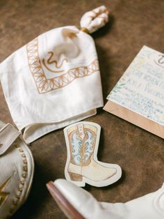 an assortment of items on a table including a cowboy boot, notepad and handkerchief