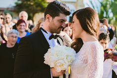 a bride and groom standing in front of an audience