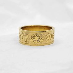 men's buddhist lotus flower om mani padme hum ring 2 made in 14k solid gold or 18k solid gold ॐ मणि पद्मे हूँ (english: om mani padme hum) that is the six-syllabled  sanskrit mantra and a lotus flower is on the side of it. - width 8.7mm - materials: real 14k solid gold, real 18k solid gold - free shipping on all orders - designed by carre d'or - made in south korea 14k gold ring weight 6.5 US 6.56g (±3%) 7.0 US 6.80g (±3%) 7.5 US 6.92g (±3%) 8.0 US 7.04g (±3%) 8.5 US 7.34g (±3%) 9.0 US 7.42g (±3%) 9.5 US 7.53g (±3%) 10.0 US 7.66g (±3%) 10.5 US 7.79g (±3%) 11.0 US 8.04g (±3%) 11.5 US 8.15g (±3%) 12.0 US 8.28g (±3%) 12.5 US 8.41g (±3%) 13.0 US 8.52g (±3%) 18k gold ring weight 6.5 US 7.81g (±3%) 7.0 US 8.10g (±3%) 7.5 US 8.25g (±3%) 8.0 US 8.39g (±3%) 8.5 US 8.75g (±3%) 9.0 US 8.84g (±3%) 9.5 Yellow Gold Ring For Puja, Spiritual Engraved Wedding Ring, Spiritual Engraved Ring For Anniversary, Spiritual Yellow Gold Engraved Ring In Brass, Spiritual 14k Gold Engraved Ring, Spiritual Engraved Yellow Gold Ring In Brass, Spiritual Yellow Gold Engraved Brass Ring, Spiritual Engraved 14k Gold Ring, Symbolic Yellow Gold Jewelry For Puja