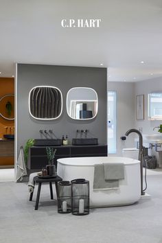 a bathroom with a bathtub, sink and mirror on the wall next to it