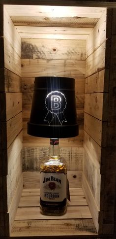 a light that is on top of a bottle in a wooden crate with a lamp