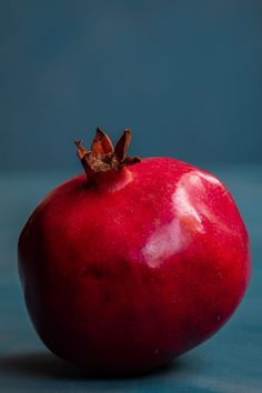 an apple with a bite taken out of it sitting on a blue tableclothed surface