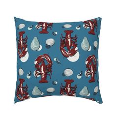 a blue pillow with red lobsters and shells on the front, along with white seashells