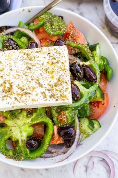 a salad with olives, tomatoes and feta cheese