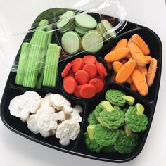 a black tray filled with lots of different types of cookies and candies on top of each other