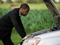 a man looking under the hood of a car