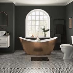 a bathroom with a gold bathtub in the center and a toilet on the other side