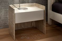 a white sink sitting on top of a wooden floor next to a wall mounted faucet