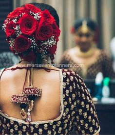 the back of a woman's dress with flowers on her head and name written on it