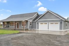 a large gray house with two garages