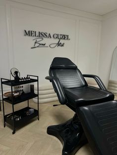 a salon chair sitting in front of a wall with the name mellissa guuzel on it