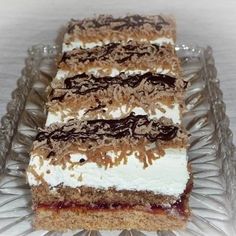 three slices of cake sitting on top of a glass platter covered in frosting