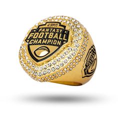 a gold ring with the words fantasy football champion surrounded by crystal stones on a white background