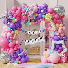 a balloon arch decorated with musical instruments and balloons