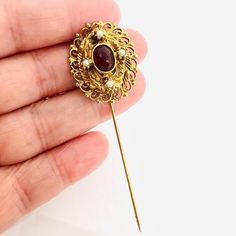 Beautiful Vintage Large Ruby Red Glass Cabochon & Faux Pearl Filigree Stick Pin Brooch. Gold plated filigree metal set with ruby red glass and faux pearls. In excellent vintage condition with minimal age appropriate wear. Measures 2 3/4 inches long by just under 1 inch wide Red Vintage Necklace With Cabochon, Ornate Red Cabochon Jewelry, Vintage Gold Cabochon Brooch, Luxury Victorian Red Brooches, Ornate Red Jewelry Brooch, Vintage Designer Jewelry, Stick Pins, Vintage Designer, Red Glass