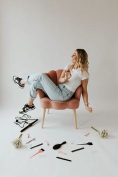 a woman sitting in a chair with lots of tools scattered around her on the floor