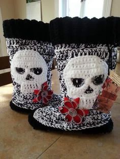 two crocheted boots with skulls and bows on them, both decorated in black and white