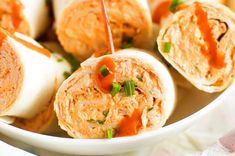 a white bowl filled with some kind of appetizer roll on top of a table