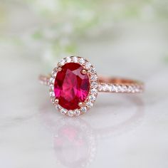 Beautiful Vintage Inspired Ruby Ring ►Base Metal: Sterling Silver (S925) ►Plating: 14K Rose Gold Vermeil ►Accented With Simulated Diamonds ►Can be paired with one or two half-eternity Milgrain bands of your choice Center Stone: Ruby Grade: AAA Stone Cut: Oval Gem size: 8.0 x 6.0 mm Carat Weight: 1.21 ct. Gemstone creation: 100% Genuine Lab-Grown Ruby Stone Origin: Russia ►Please be aware that plated jewelry can wear off over time, if this is a concern we would suggest going with the sterling sil Classic Rose Gold Rings With Accent Stones, Classic Ruby Ring With Halo Setting For Promise, Classic Halo Ruby Promise Ring, Rose Gold Ruby Wedding Ring With Prong Setting, Oval Rose Gold Birthstone Ring For Anniversary, Classic Ruby Ring With Center Stone For Promise, Classic Ruby Ring For Valentine's Day Wedding, Halo Design Wedding Ring For Valentine's Day, Valentine's Day Formal Rings With Halo Design