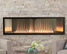 a living room with two chairs and a fire place in the wall that has flames on it