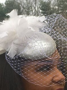 Perfect for the Bride!Silver metallic leather with a crocodile embossed pattern.Small button fascinator trimmed with a handmade cluster of white feathers made to give height and interest to this special piece.The white veiling and white velvet leaves give the finished look of mystery and beauty.This one has sold ... Allow 2 to 3 weeks for delivery of a special order. Glamorous Silver Bridal Accessories For Evening, Wedding Feather Headpiece For Royal Ascot, Wedding Headpiece With Feathers For Royal Ascot, Silver Evening Fascinator For Kentucky Derby, Silver Fascinator For Evening At Kentucky Derby, Elegant Silver Fascinator For Wedding, Silver Evening Headpiece For Royal Ascot, Silver Headpiece For Evening At Royal Ascot, Elegant Silver Wedding Fascinator