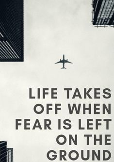 an airplane is flying in the sky above some tall buildings with a quote on it