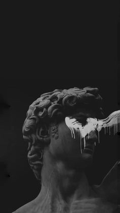 a black and white photo of a statue with icicles on his face