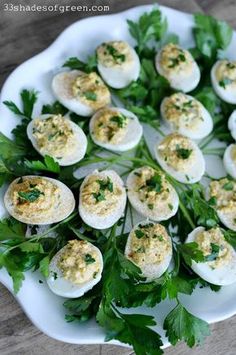 deviled eggs with parsley on a white plate