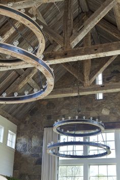 a chandelier hanging from the ceiling in a room with stone walls and windows